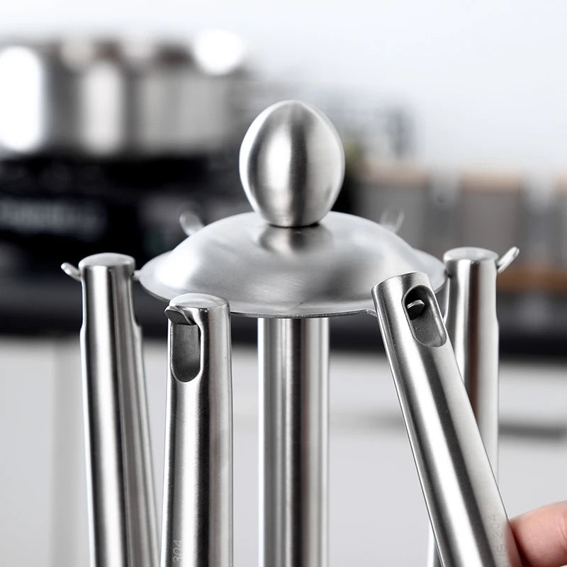 Soporte organizador para utensilios de cocina de acero inoxidable con carrusel giratorio de 360 grados y 6 ganchos.